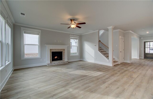 unfurnished living room with crown molding, a fireplace, ceiling fan, and light hardwood / wood-style flooring