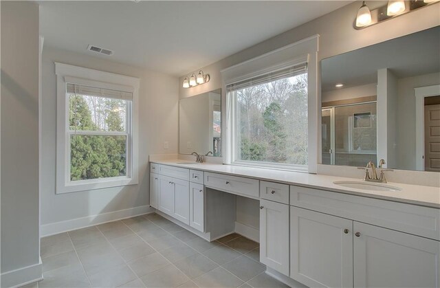 bathroom featuring vanity, tile patterned floors, and a shower with door