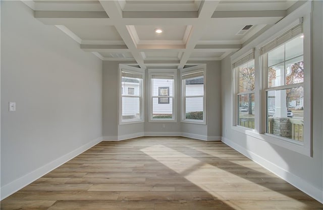 unfurnished sunroom with beam ceiling, a healthy amount of sunlight, and coffered ceiling