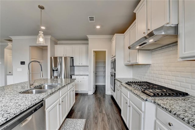 kitchen with hanging light fixtures, appliances with stainless steel finishes, sink, and white cabinets