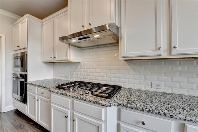 kitchen with ventilation hood, white cabinets, ornamental molding, stainless steel appliances, and light stone countertops