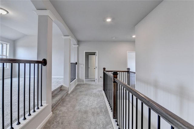 corridor featuring vaulted ceiling and light carpet