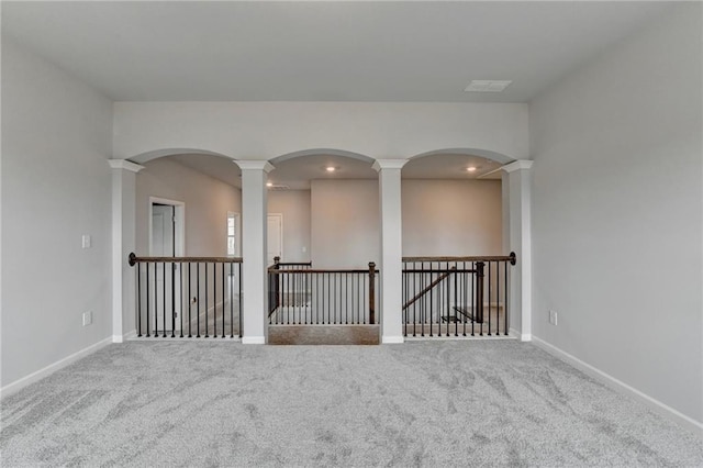 carpeted spare room featuring ornate columns