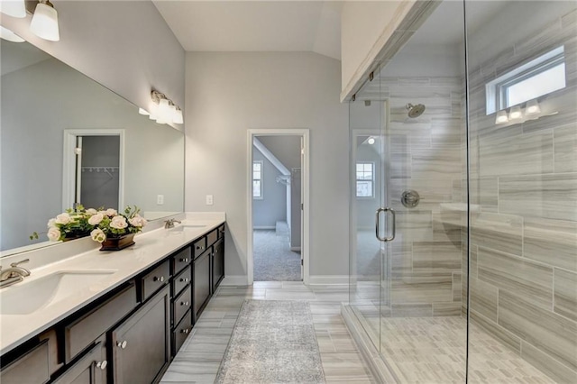 bathroom with vanity, a shower with shower door, tile patterned floors, and vaulted ceiling