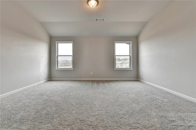 unfurnished room with carpet flooring and vaulted ceiling