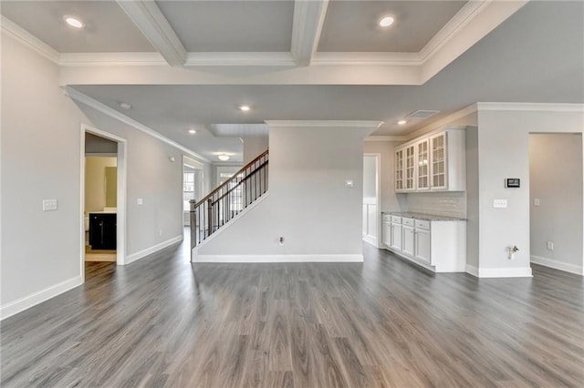 unfurnished living room featuring beamed ceiling, ornamental molding, and dark hardwood / wood-style flooring