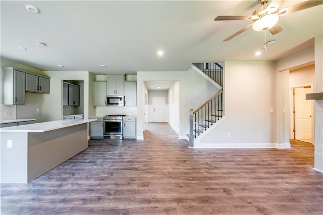 kitchen featuring ceiling fan, stainless steel appliances, gray cabinetry, and light hardwood / wood-style floors