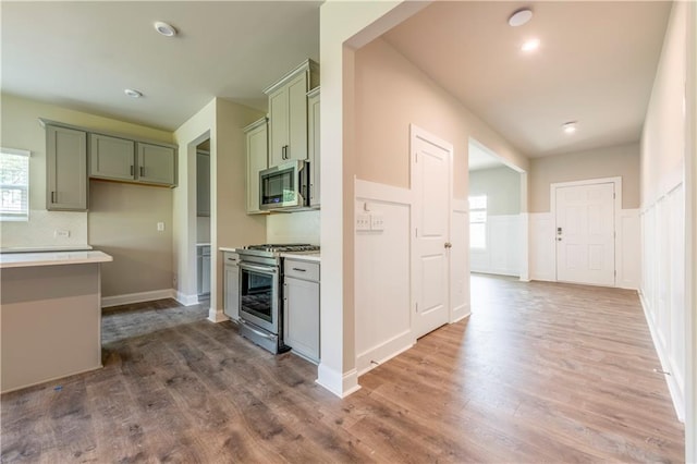 kitchen featuring stainless steel appliances, tasteful backsplash, and light hardwood / wood-style flooring