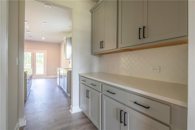 kitchen featuring sink, light wood-type flooring, and tasteful backsplash