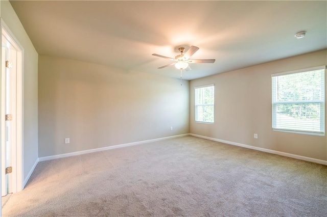 empty room featuring light colored carpet and ceiling fan