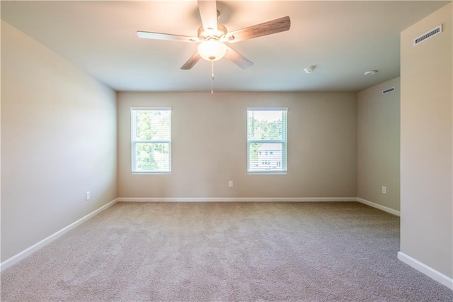 spare room featuring ceiling fan and light carpet