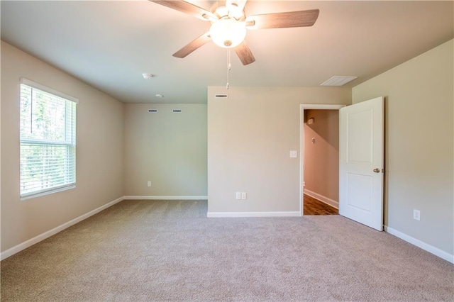 carpeted spare room featuring ceiling fan