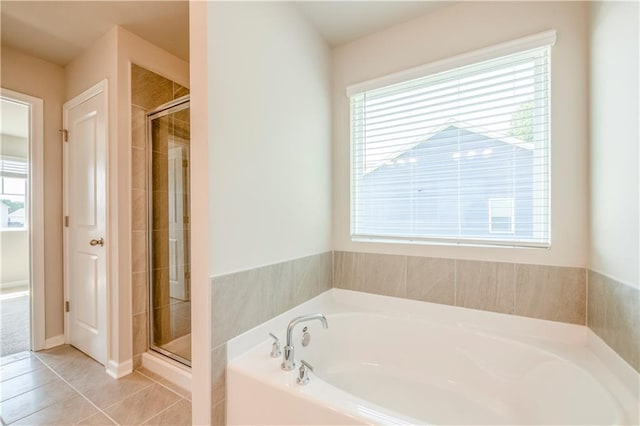 bathroom featuring plus walk in shower, a wealth of natural light, and tile patterned floors