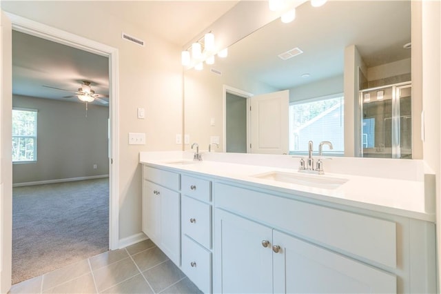 bathroom featuring tile patterned flooring, ceiling fan, a shower with door, and vanity