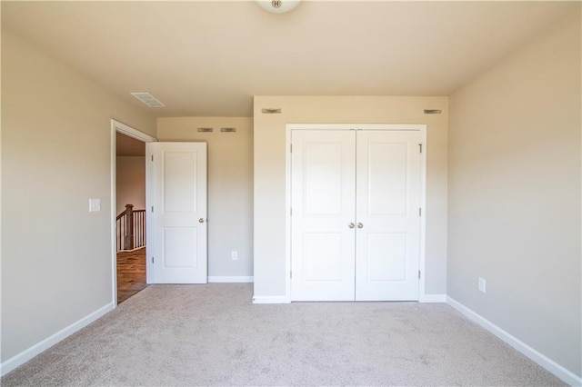 unfurnished bedroom featuring a closet and light carpet