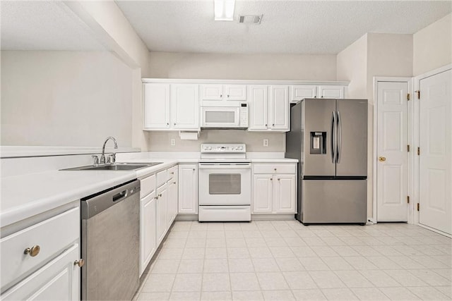 kitchen with visible vents, stainless steel appliances, light countertops, white cabinetry, and a sink