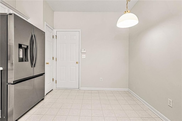 kitchen featuring baseboards, pendant lighting, and stainless steel refrigerator with ice dispenser