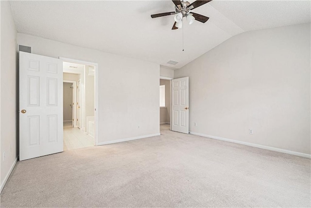 unfurnished bedroom with carpet floors, vaulted ceiling, ceiling fan, ensuite bath, and baseboards