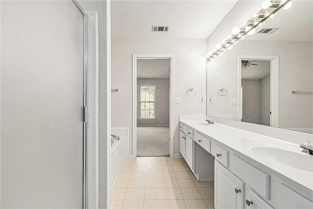 full bathroom featuring a textured ceiling, a sink, and visible vents