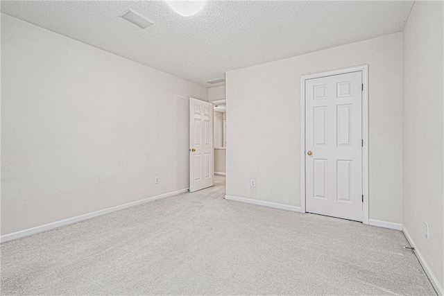 unfurnished bedroom featuring a textured ceiling, baseboards, and carpet flooring