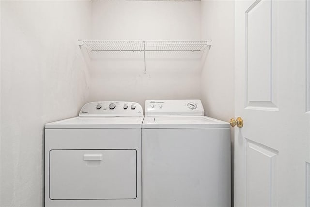 clothes washing area featuring separate washer and dryer and laundry area