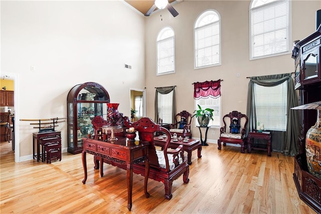 1227 Castle Point Ct SW, Conyers, GA 30094 - living room featuring a high ceiling, a ceiling fan, and light wood-style flooring
