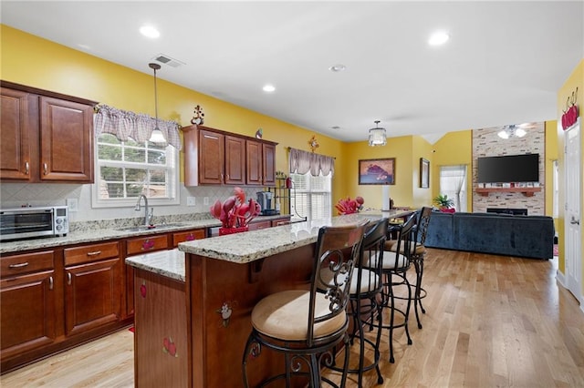 1227 Castle Point Ct SW, Conyers, GA 30094 - kitchen featuring a breakfast bar, tasteful backsplash, light stone countertops, light wood-style flooring, and recessed lighting