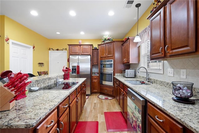 1227 Castle Point Ct SW, Conyers, GA 30094 - kitchen with stainless steel appliances, a center island, light wood-style floors, tasteful backsplash, and hanging light fixtures