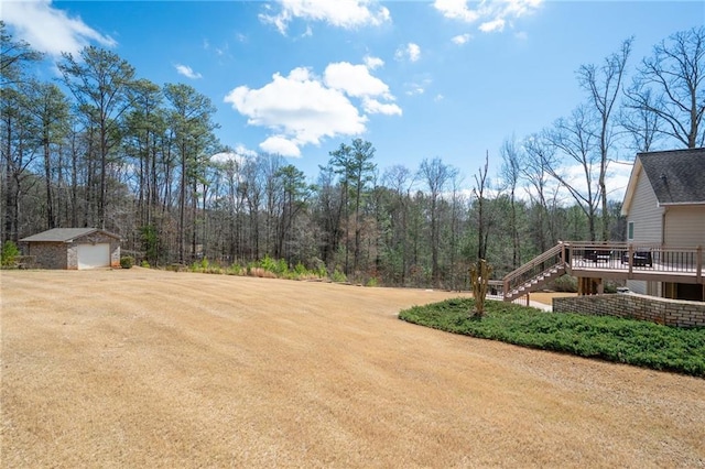 1227 Castle Point Ct SW, Conyers, GA 30094 - view of yard featuring a wooden deck, stairs, an outdoor structure, a forest view, and a garage