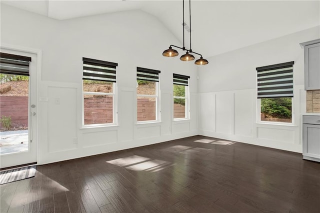unfurnished dining area with wainscoting, a decorative wall, and plenty of natural light