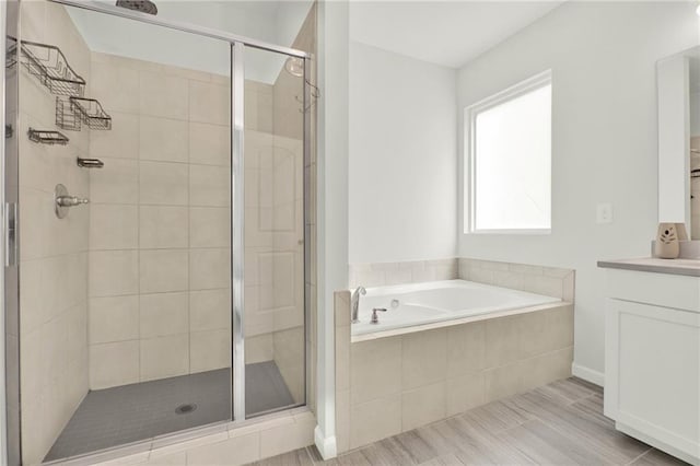 bathroom featuring a garden tub, vanity, and a stall shower
