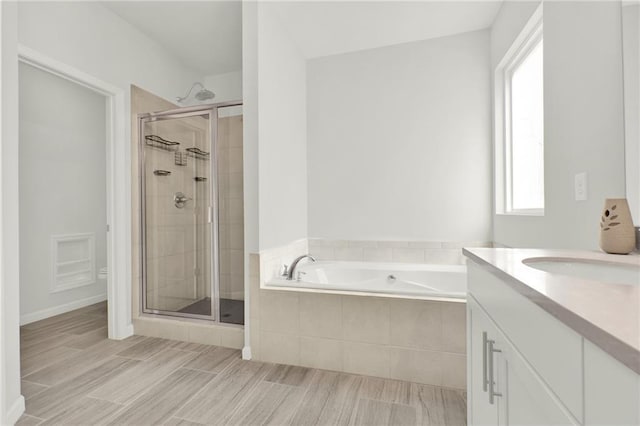 bathroom featuring a bath, a shower stall, and vanity
