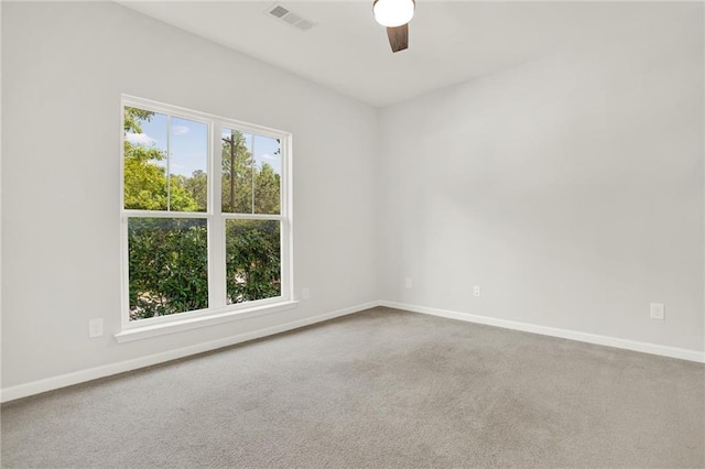 carpeted empty room featuring baseboards, a ceiling fan, and visible vents