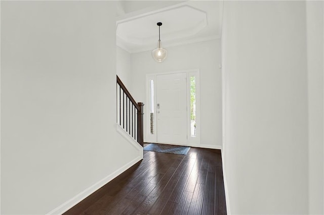 foyer featuring stairs, baseboards, dark wood-type flooring, and ornamental molding