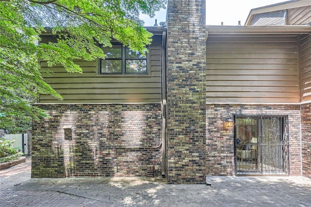 12 Westchester Sq, Decatur, GA 30030 - rear view of house featuring brick siding, a chimney, and a patio