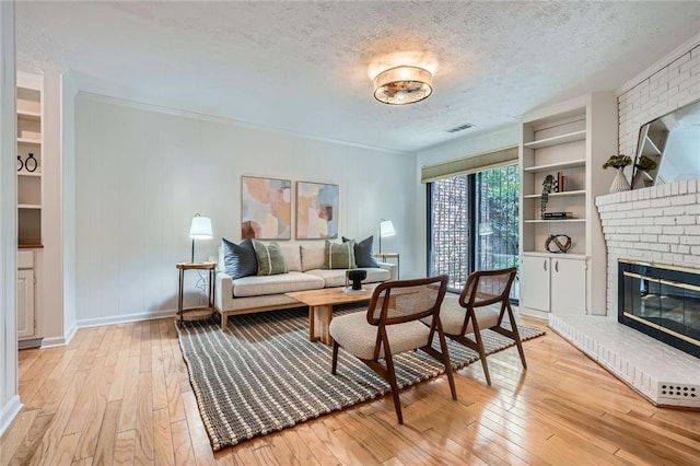 12 Westchester Sq, Decatur, GA 30030 - living room with light wood finished floors, a textured ceiling, and a brick fireplace