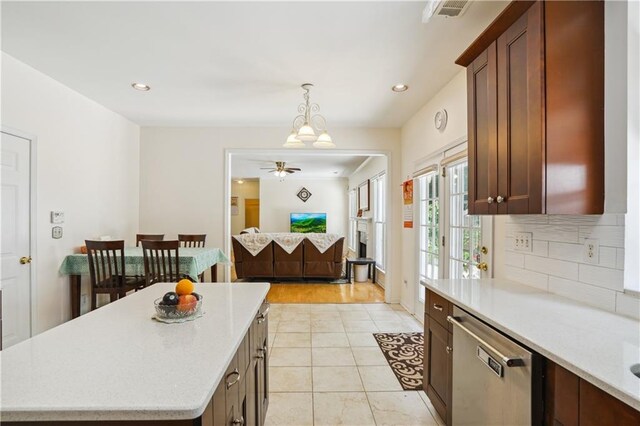 kitchen featuring a center island, pendant lighting, light countertops, and stainless steel dishwasher