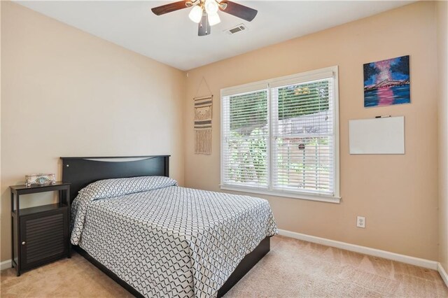 bedroom featuring baseboards, multiple windows, and light colored carpet