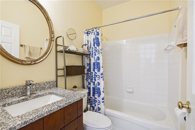 full bathroom featuring toilet, shower / tub combo with curtain, and vanity