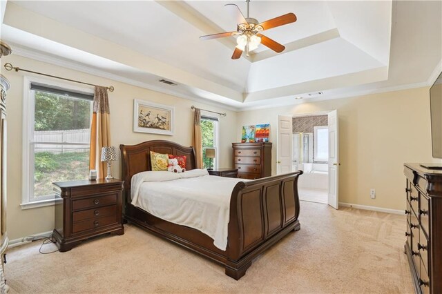 bedroom featuring connected bathroom, light carpet, visible vents, baseboards, and a tray ceiling