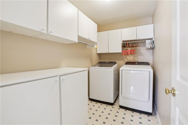 washroom with light floors, washing machine and dryer, cabinet space, and baseboards