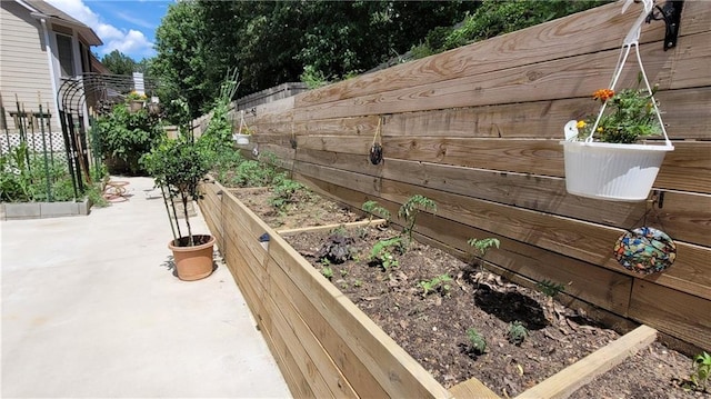 view of patio / terrace featuring a vegetable garden and fence