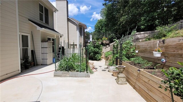 view of patio / terrace with fence and a vegetable garden