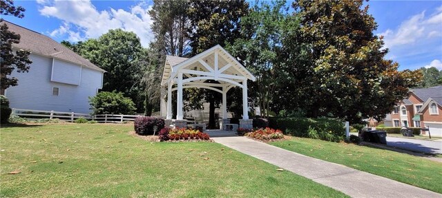 view of community featuring a yard, fence, and a gazebo