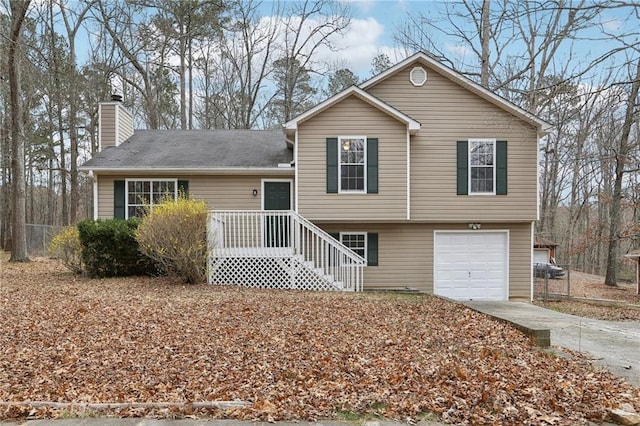 tri-level home featuring driveway, a garage, and a chimney