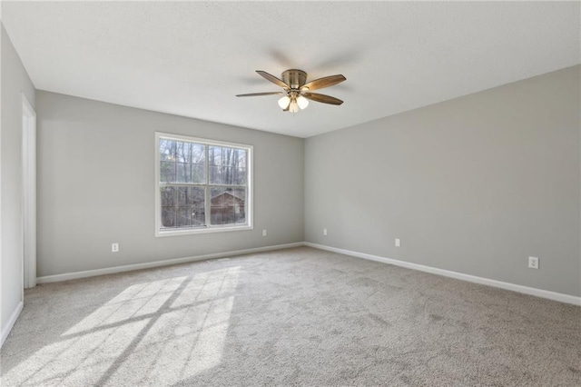 spare room featuring carpet flooring, ceiling fan, and baseboards