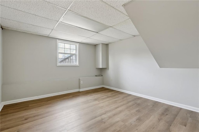 basement with baseboards, a drop ceiling, and wood finished floors