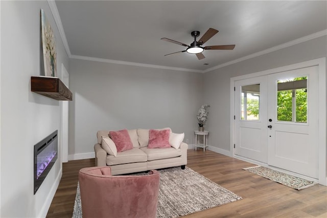 235 Lowry St, Ball Ground, GA 30107 - living room with baseboards, wood finished floors, a glass covered fireplace, a ceiling fan, and ornamental molding