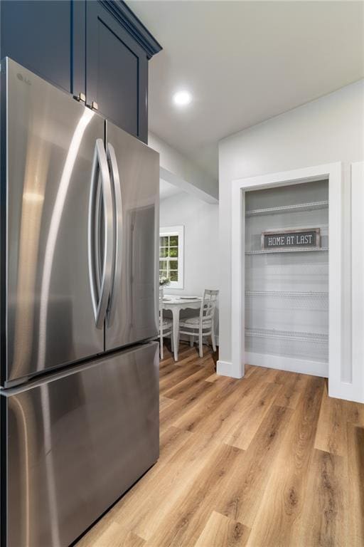 235 Lowry St, Ball Ground, GA 30107 - kitchen featuring freestanding refrigerator, blue cabinetry, and light wood-type flooring