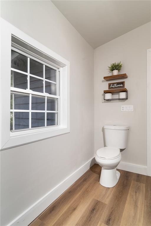 235 Lowry St, Ball Ground, GA 30107 - bathroom featuring baseboards, toilet, and wood finished floors